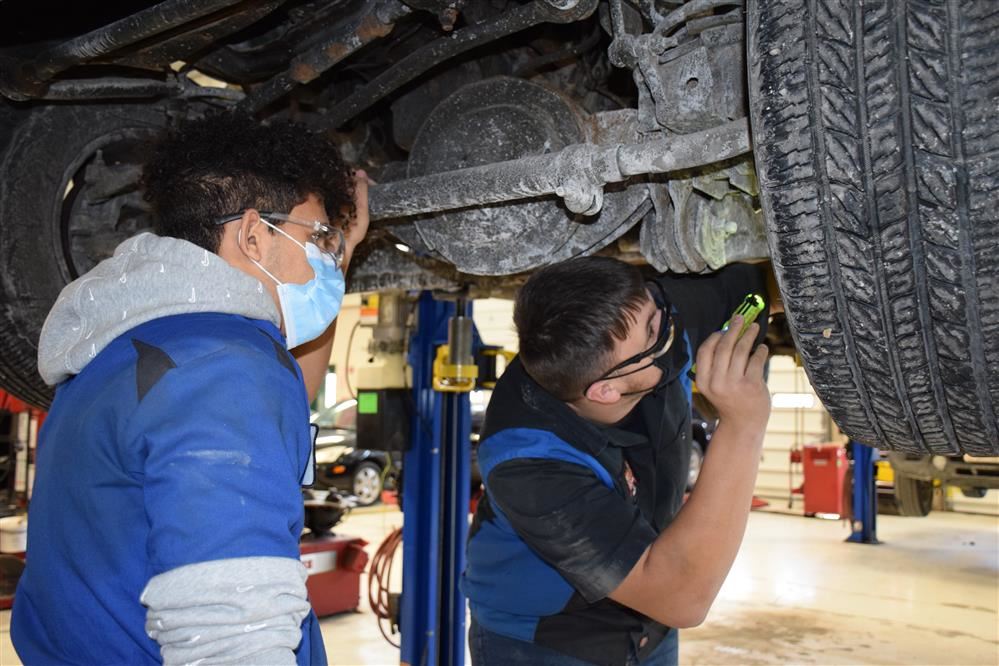  An Auto Technology student shows a sophomore visitor how to inspect brakes.